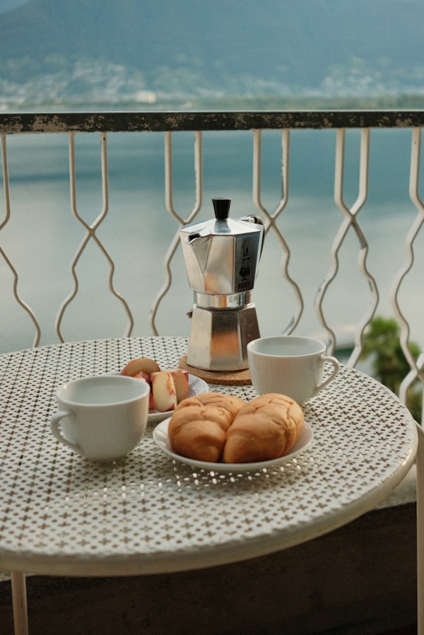 A moment of Dolce Vita at Lago Maggiore: With a stunning view of the serene lake, enjoy a relaxing morning on the balcony. Freshly brewed coffee from the Moka pot pours into the cups, while delicious croissants and fresh peaches await on the table. The gentle lapping of the water and the peaceful ambiance create the perfect backdrop for a perfect start to the day. Here, where life is savored to the fullest, time seems to stand still, and everyday worries feel far away.