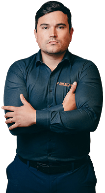 Man with crossed arms wearing a dark blue shirt with a company logo.