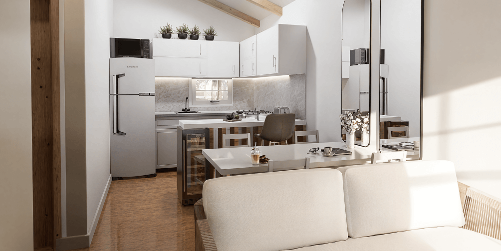 Modern kitchen and dining area with beige sofa, white cabinets, refrigerator, dining table with chairs, and wall mirror reflecting the room.