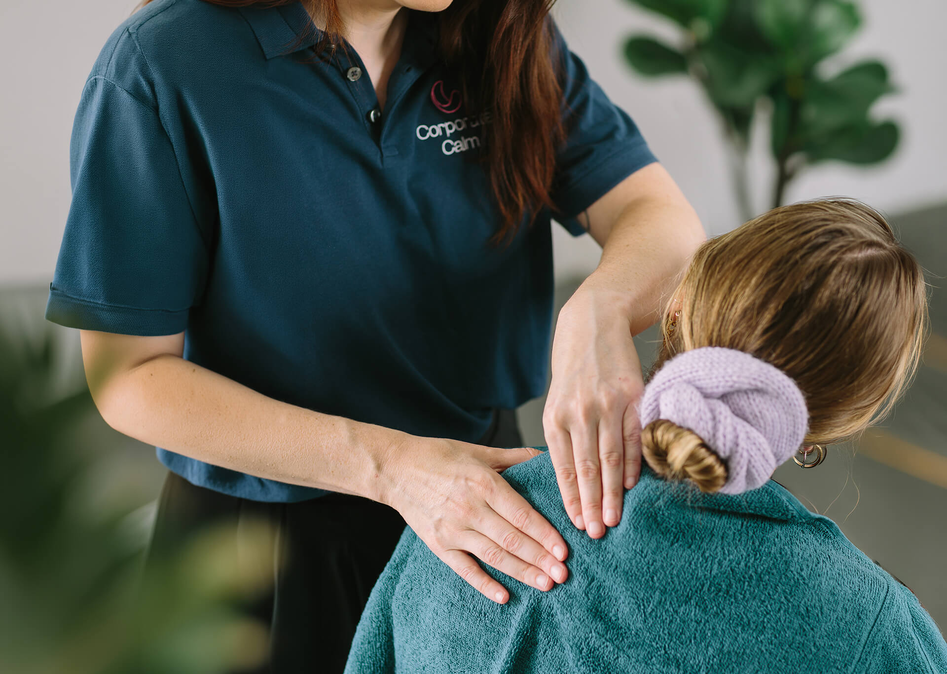 Corporate Calm therapist delivering a shoulder massage for an employee during an on-site office massage session