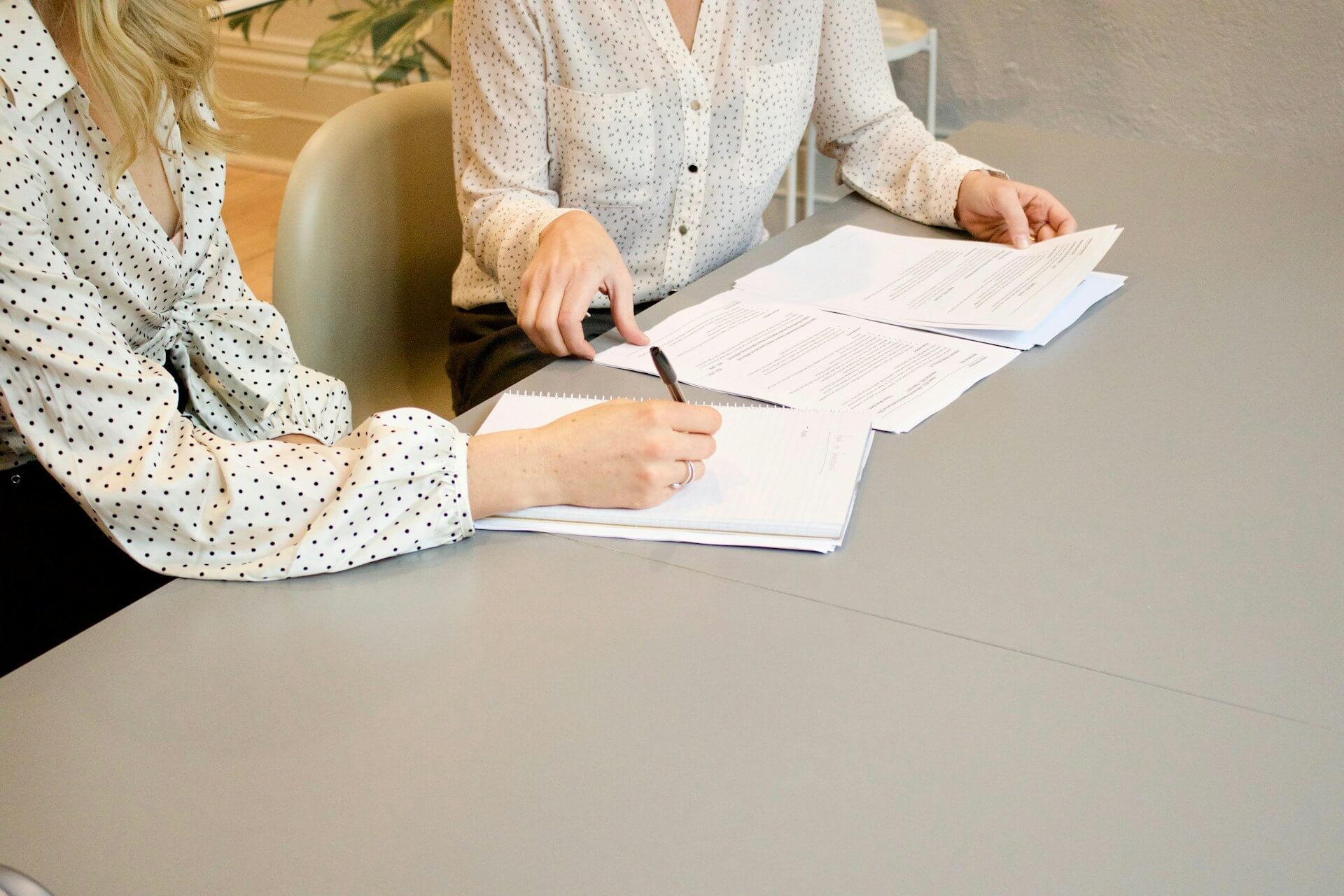 Two finance professionals reviewing paperwork and documents at a desk