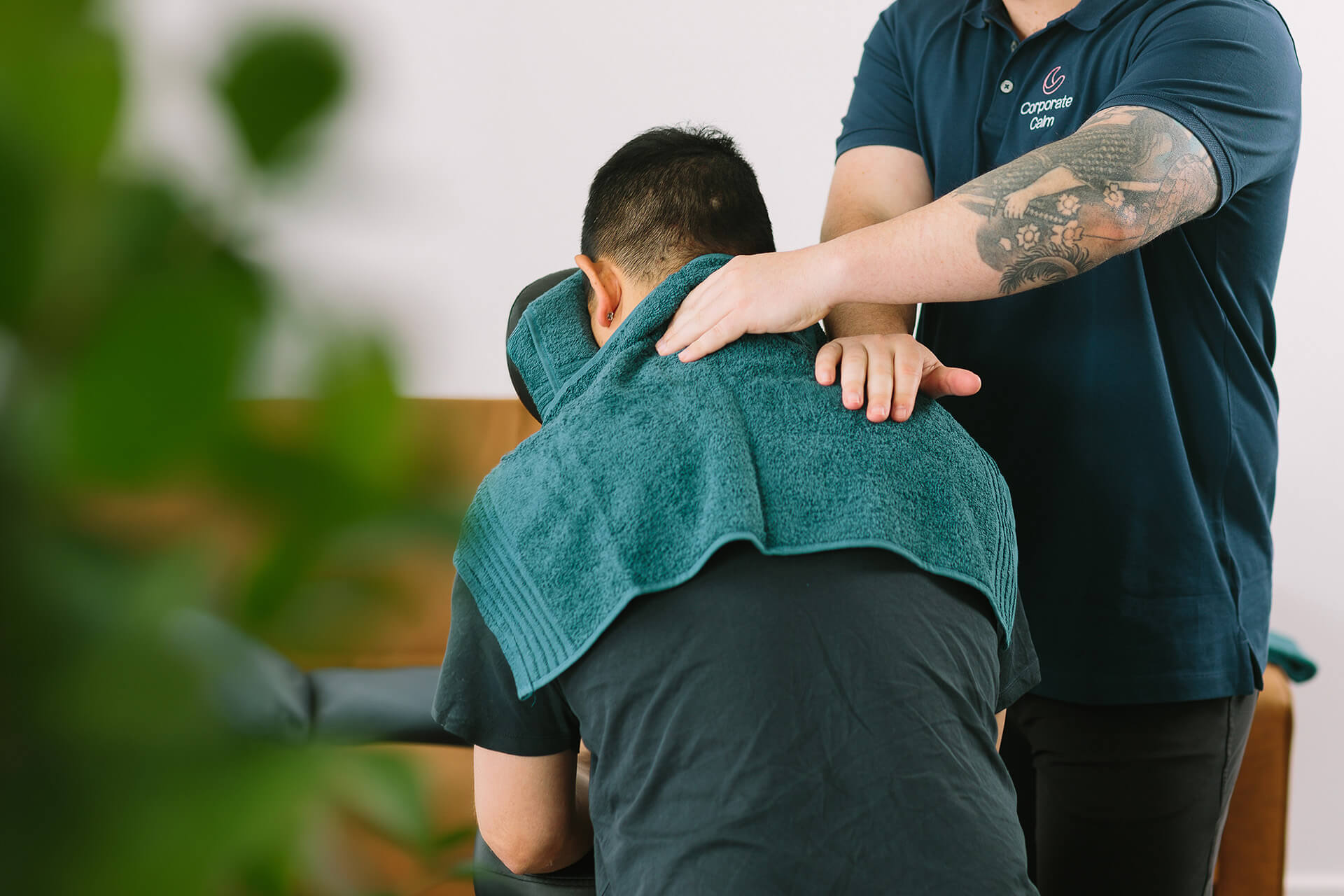 Corporate Calm therapist delivering a workplace chair massage to an employee in an office