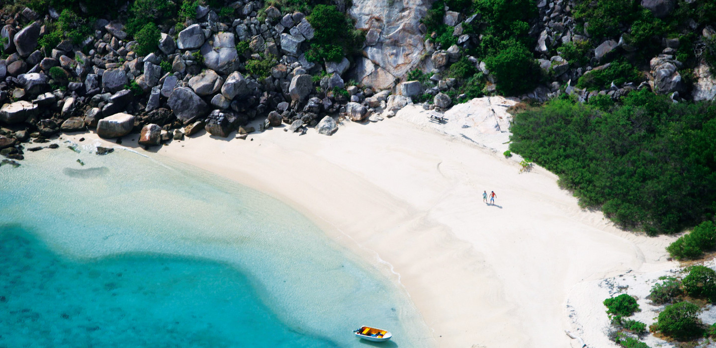 A collection of photographs showcasing the turquoise waters, pristine beaches, and sailing activities of Lizard Island and The Whitsundays.
