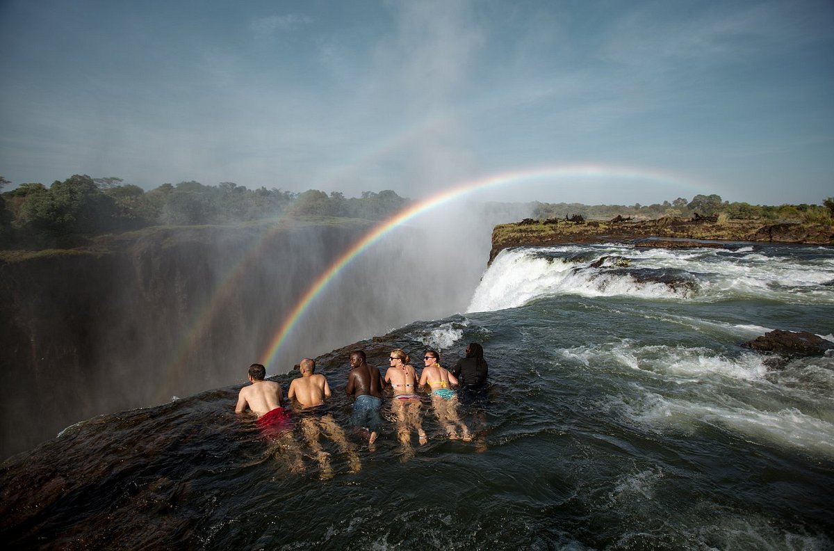 A collection of photographs showcasing Zambia's authentic safari experiences: walking safaris, river canoeing, and Victoria Falls.