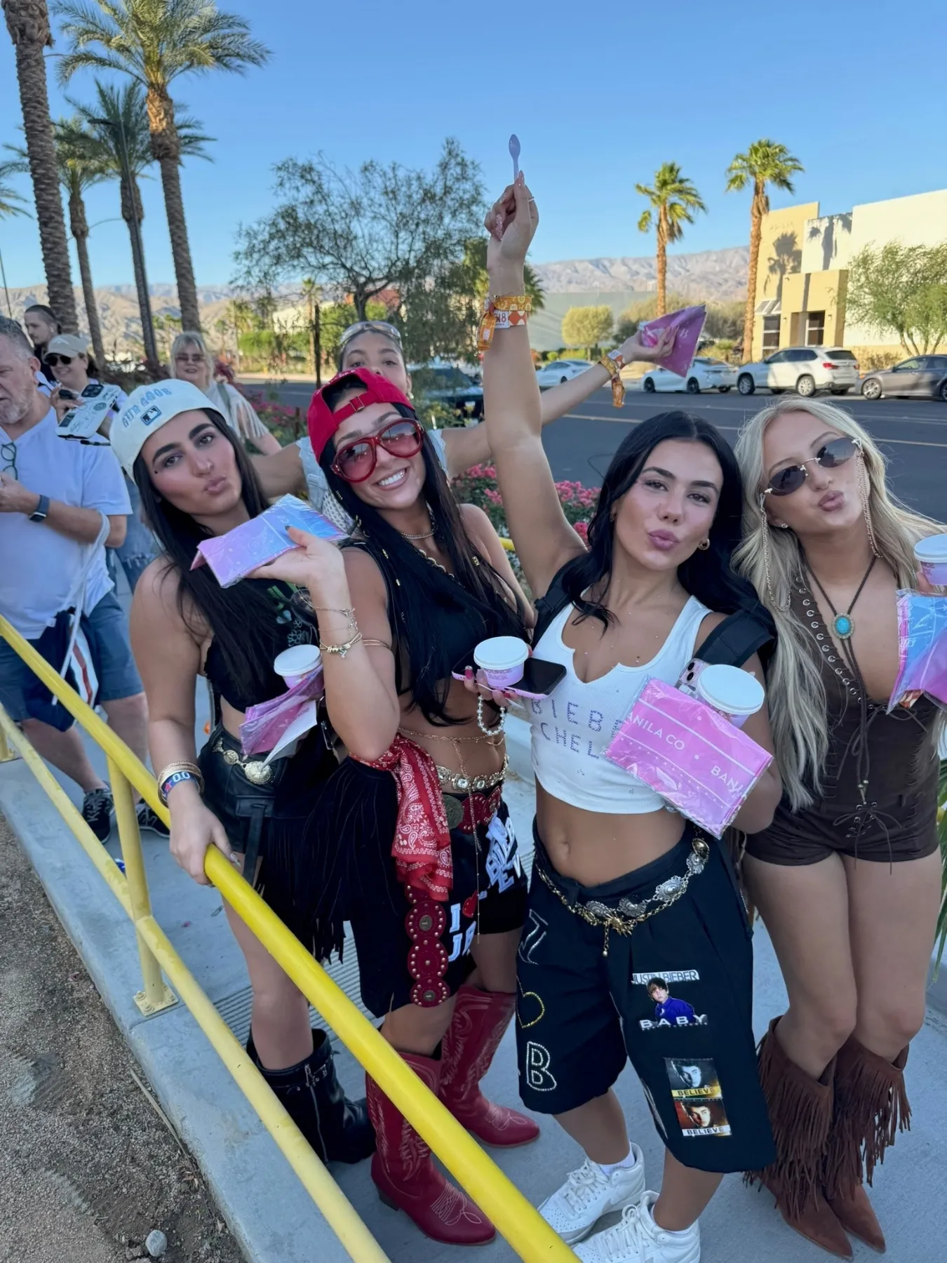 Coachella festivalgoers holding Banila Co product samples and giveaway materials in Palm Springs.