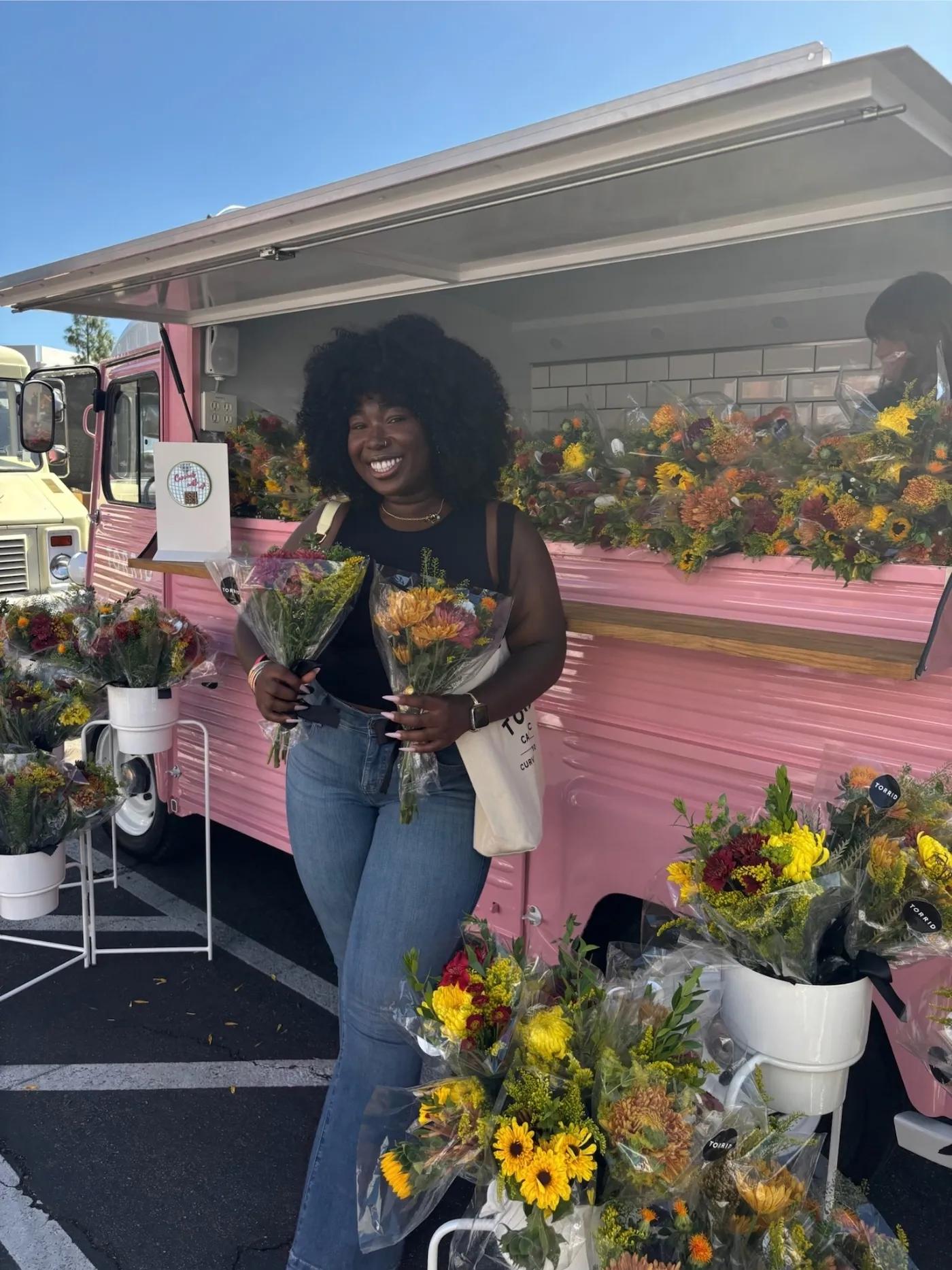 Torrid Casting Call participant holding bouquets in front of Retro Roll’s pink Citroën flower truck