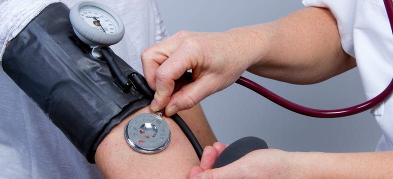 Bild på en person som mäter blodtryck på en patient
