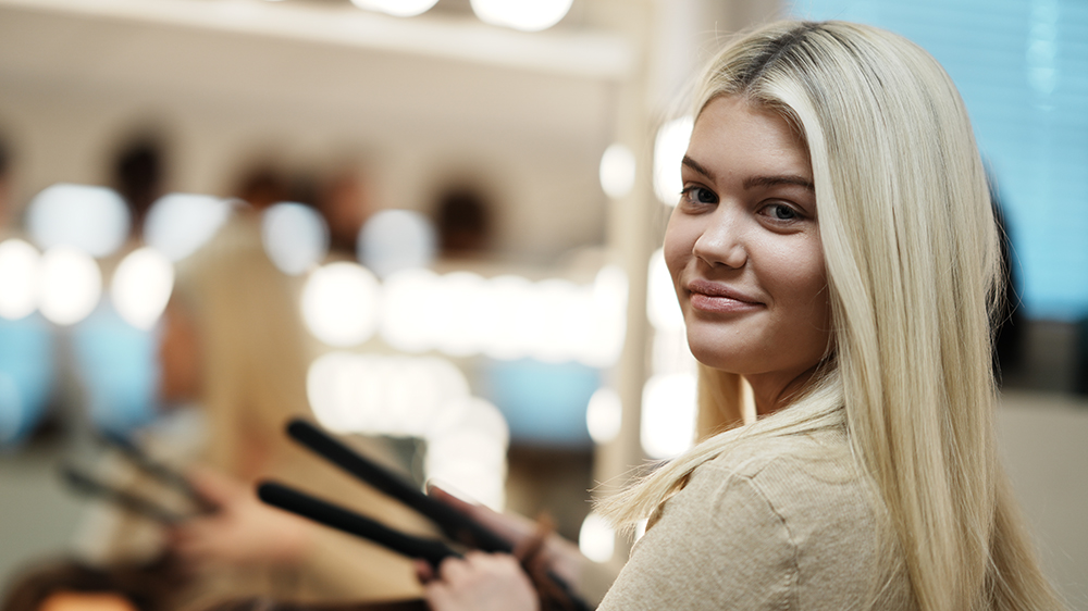 Bild på en ung frisör som klipper hår.