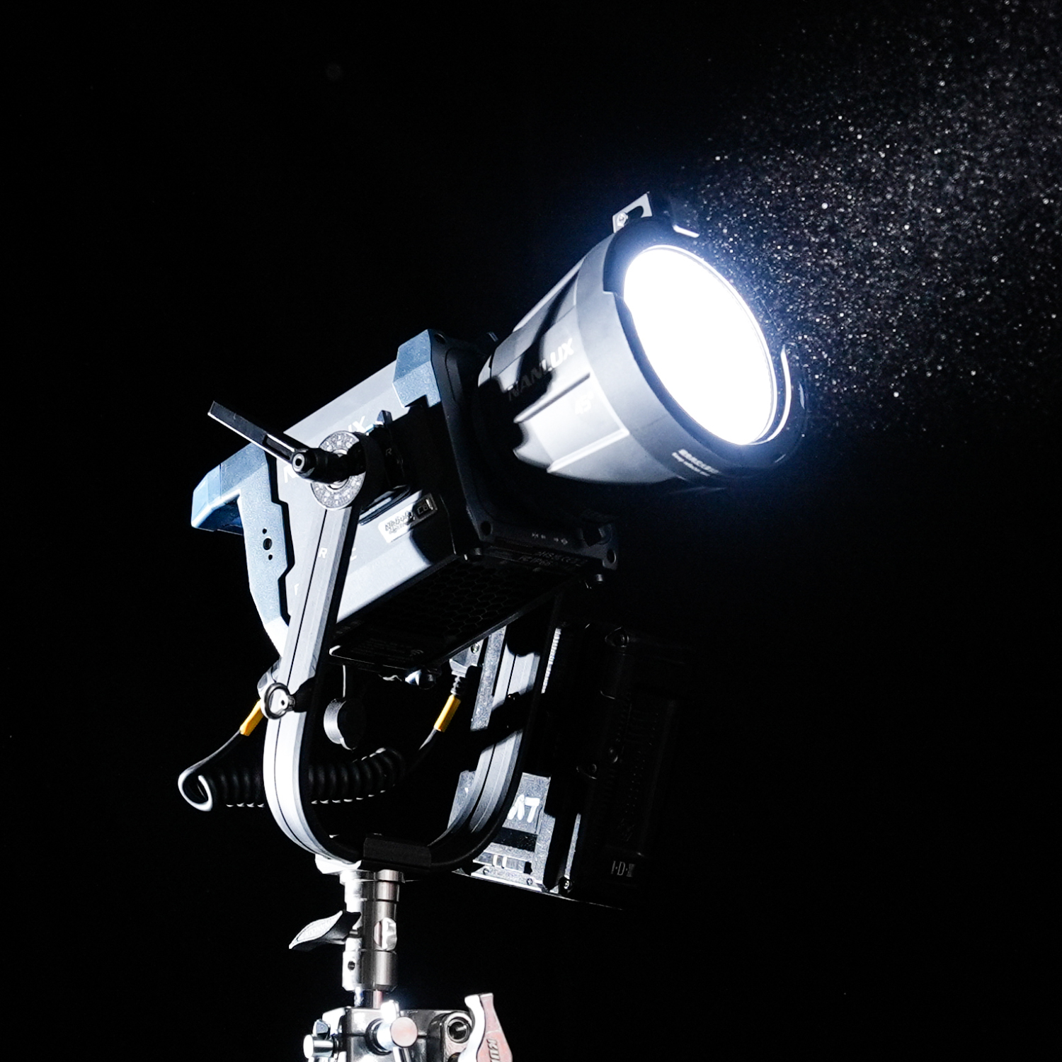Studio spotlight with bright LED light shining against a dark background, mounted on a stand.