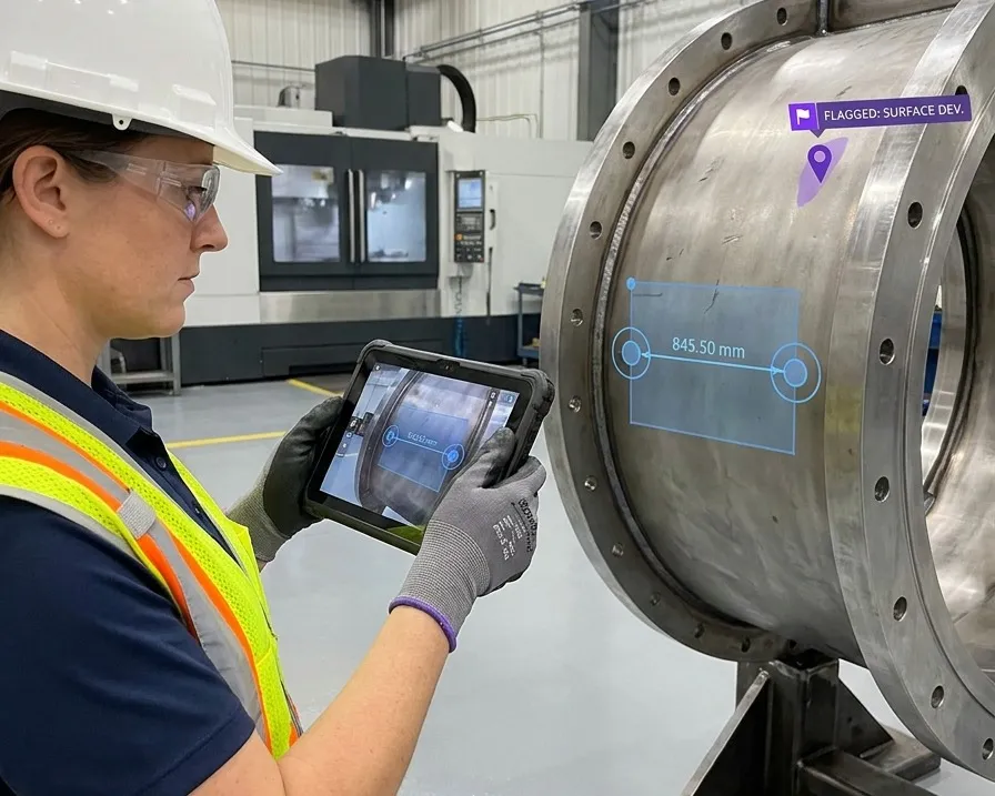 An inspector holding a tablet against a machined flange, with measurement targets and a dimension pinned to precise points on the part