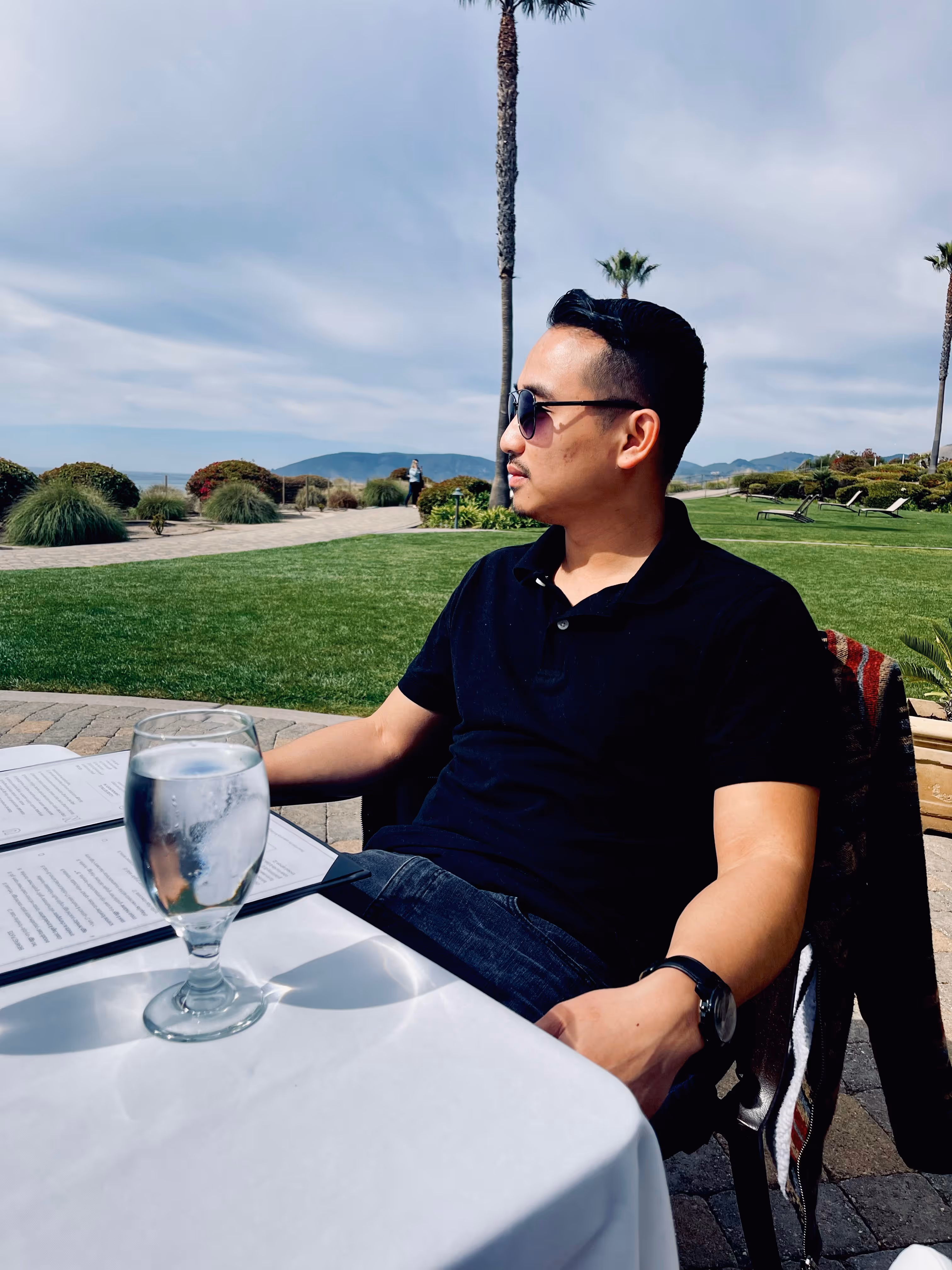 Kevin Torres, founder of PyreBrand Designs, sitting at an outdoor coastal restaurant on the Central Coast.