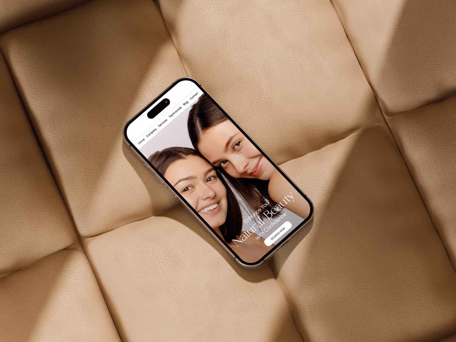 Smartphone displaying a beauty website with two smiling women on a beige leather cushion.