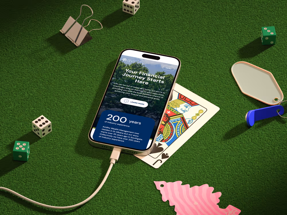 Smartphone on green felt displaying financial app screen with playing card, dice, and key tags around it.