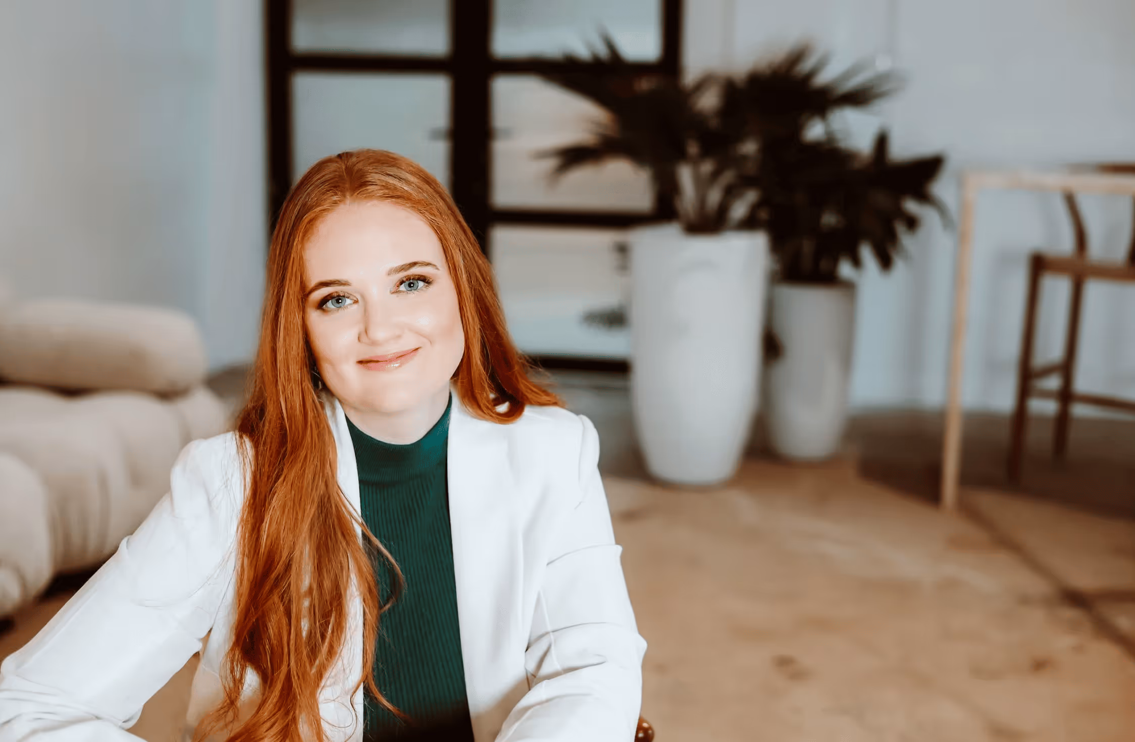 Open laptop on a round white table displaying a law firm's website featuring a smiling woman seated on a brown chair.
