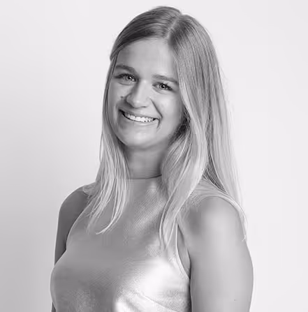 Black and white portrait of a smiling woman with long straight hair wearing a sleeveless top.