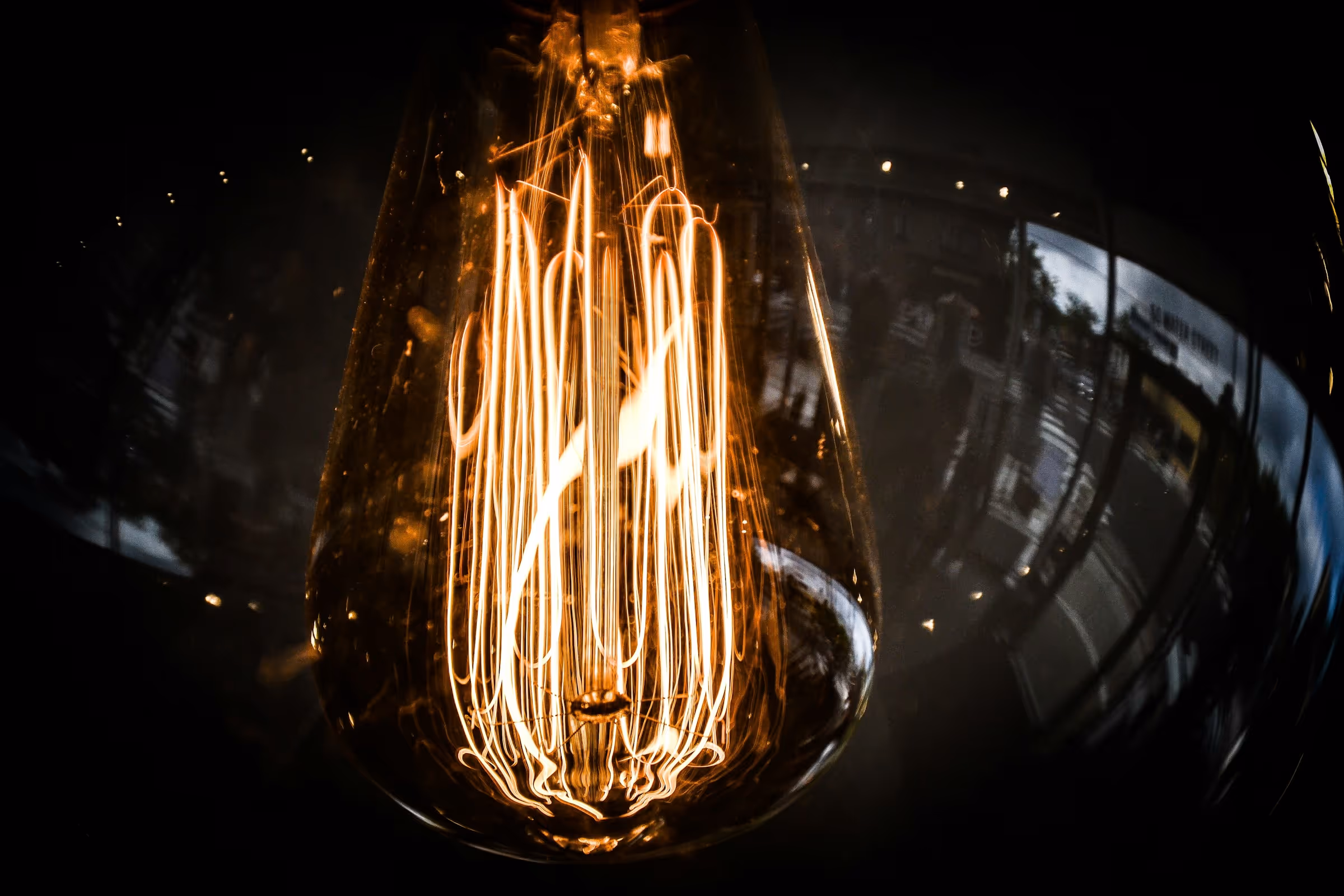 Close-up of glowing filament inside a vintage-style Edison light bulb with a dark background.