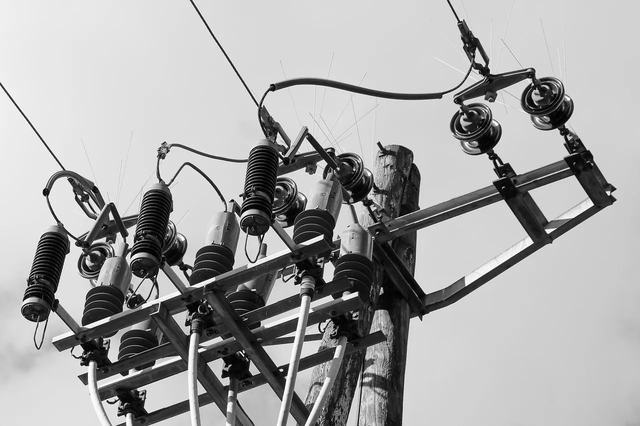 Close-up of electrical insulators and wires on a utility pole against a clear sky.