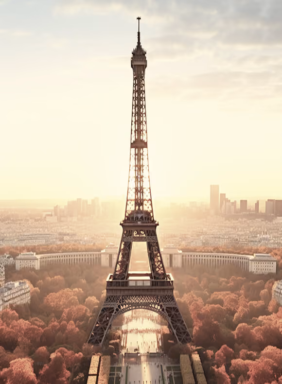 Eiffel Tower illuminated by soft sunlight with autumn-colored trees and Paris cityscape in the background.