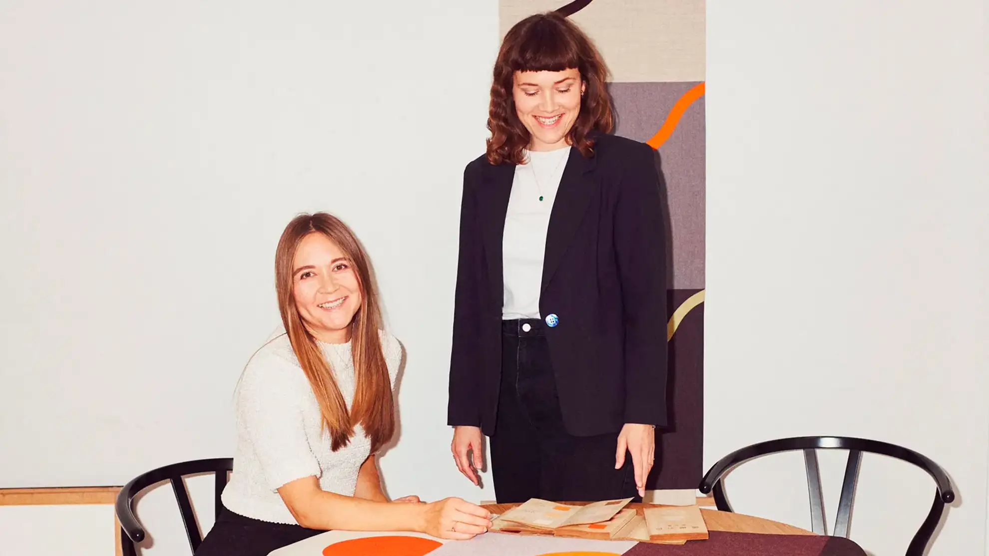 The artist duo Hvass&Hannibal at a table with one of their art pieces.