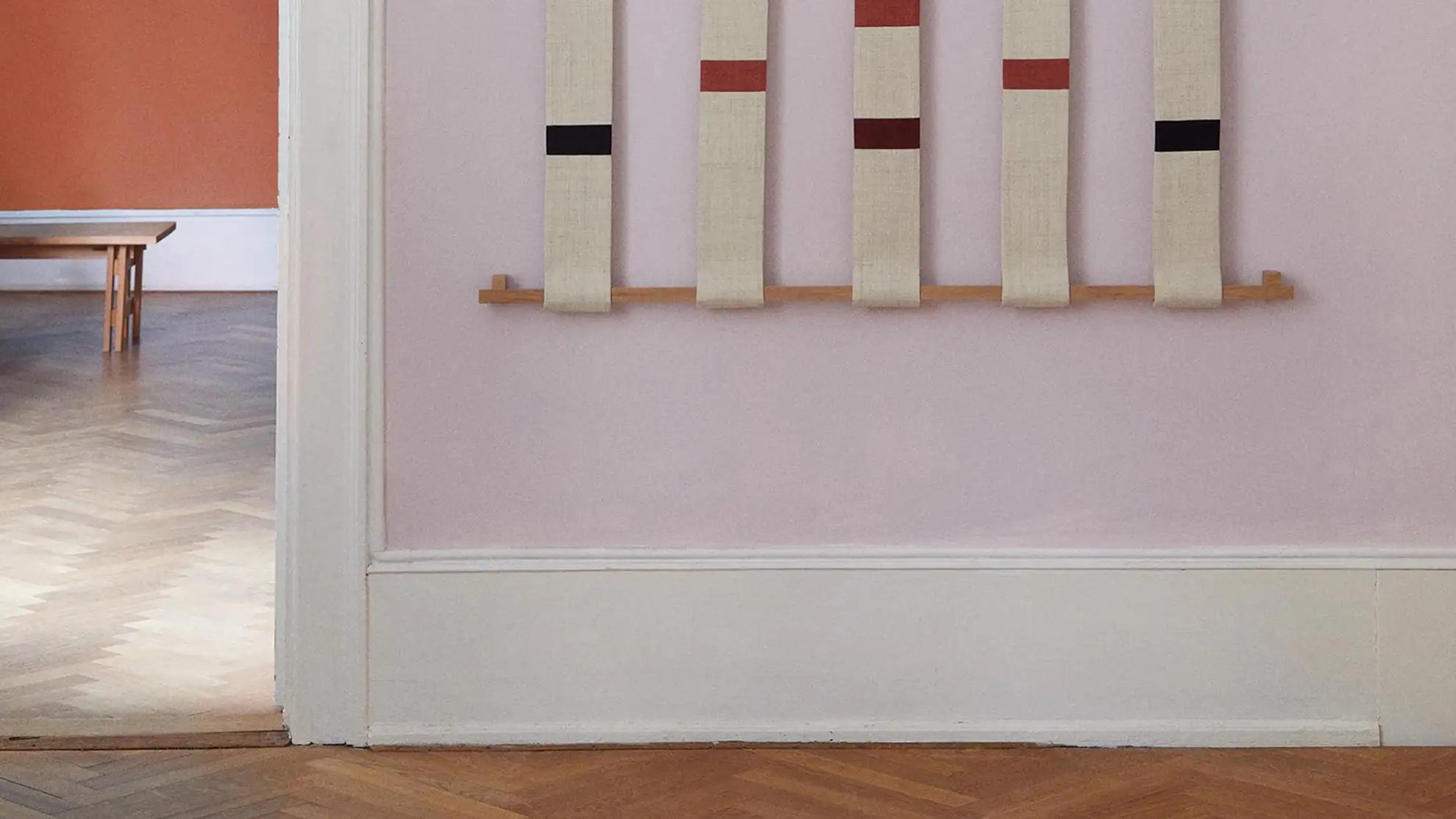 A picture from the new webshop of the textile piece called Rain hanging on a wall in a light room.