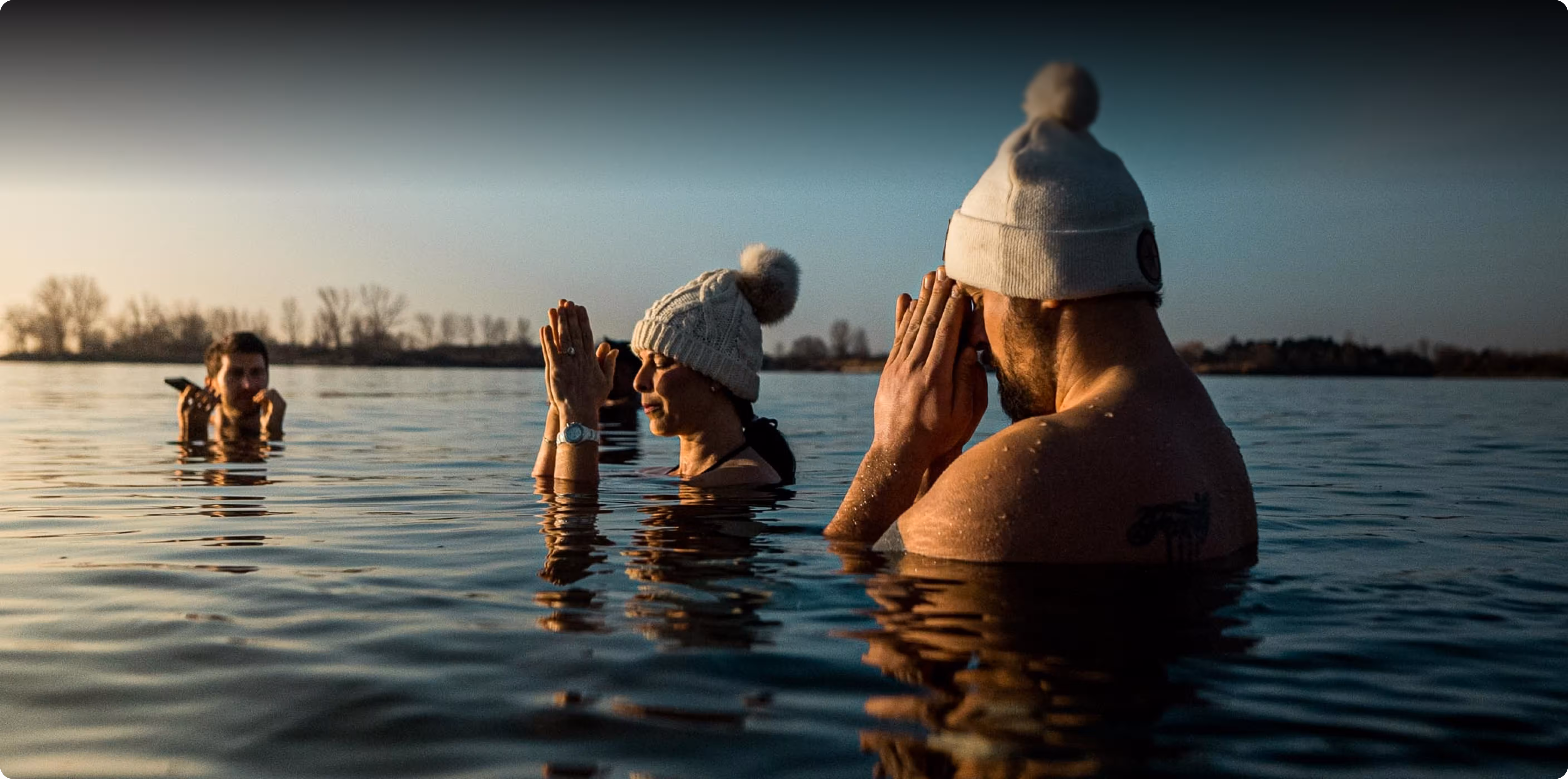  People taking a cold plunge in a lake at sunrise