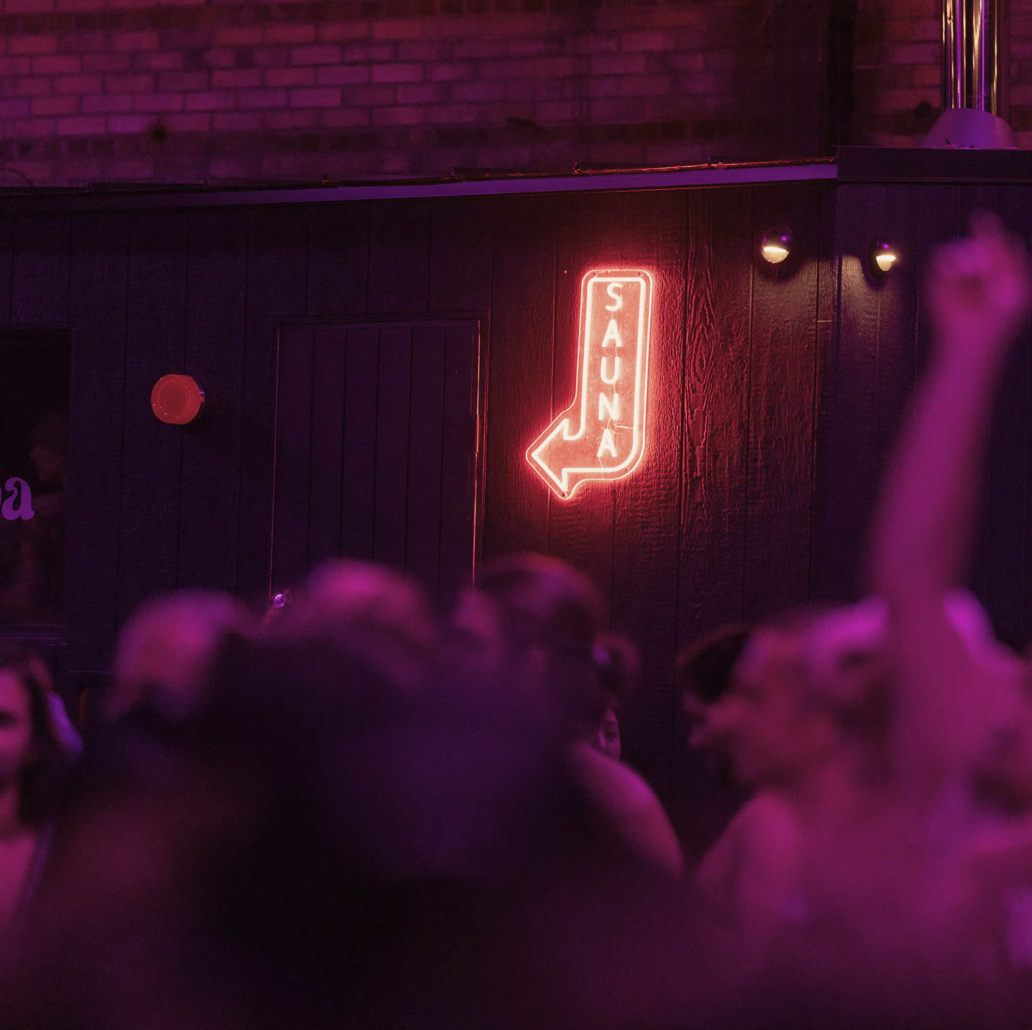 Group of diverse women doing an outdoor fitness or yoga class with arms raised.
