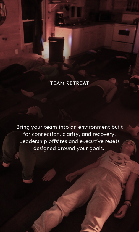 Close-up of a hand resting on a rolled towel on someone's back beside a blurred outdoor scene with tree branches.