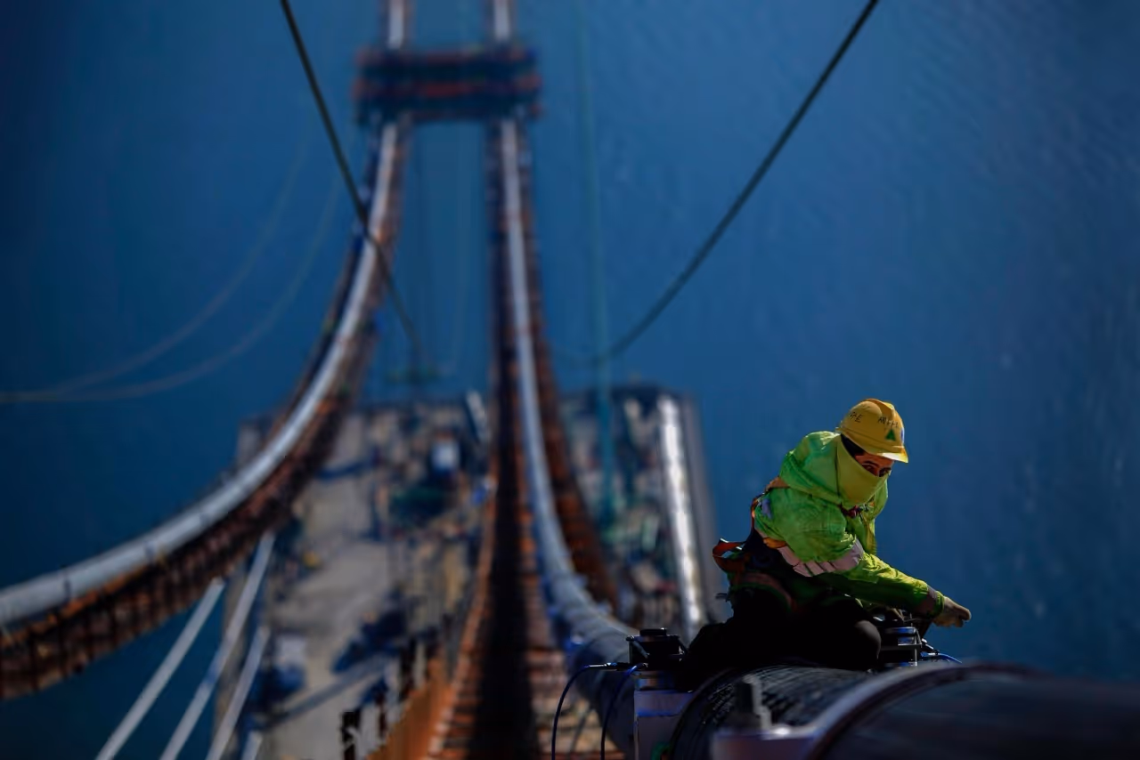 utility workers working over a bridge
