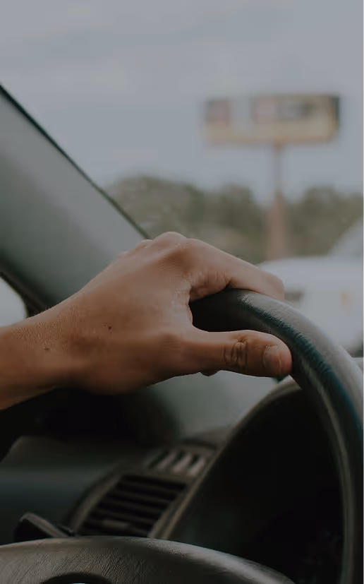 Person driving a car comfortably on an open road