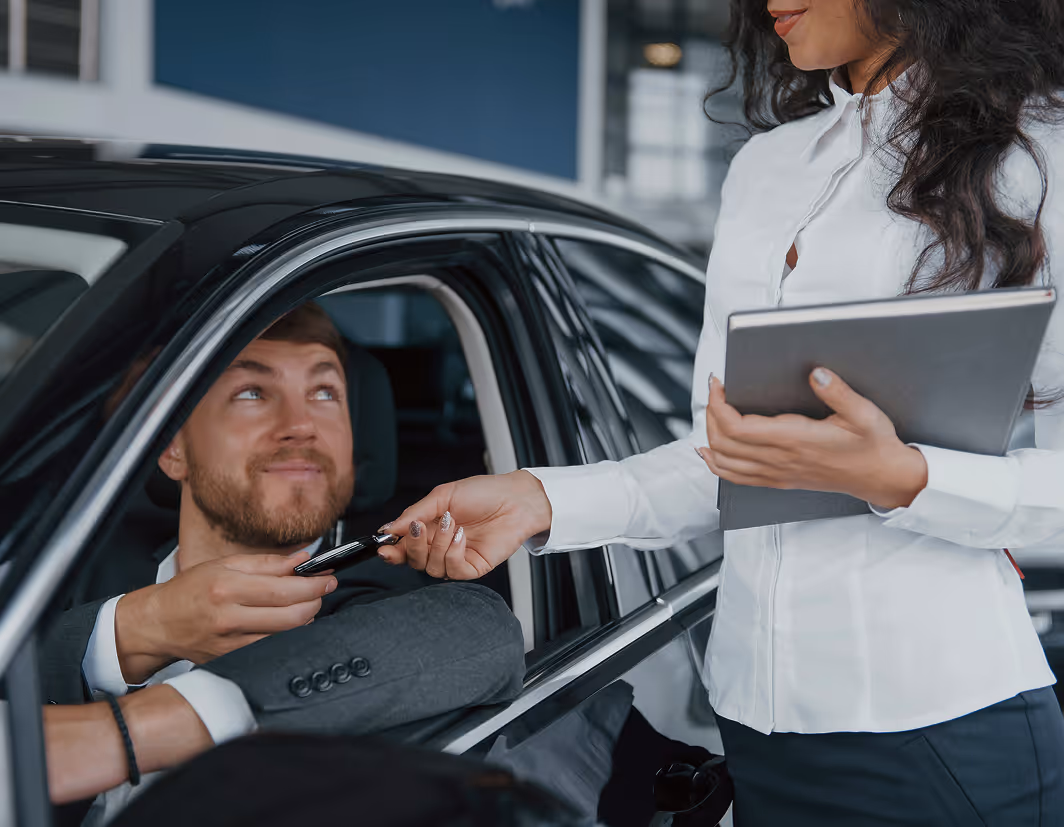 Smiling customer holding car keys after picking up a rental vehicle