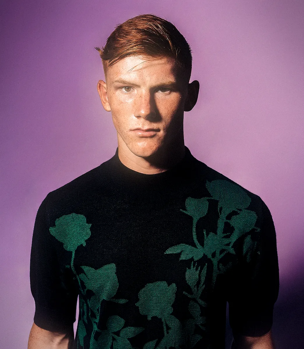Model wearing a black short-sleeve intarsia knit top with dark green floral graphics from PSEUDONYM Spring Summer 2020.