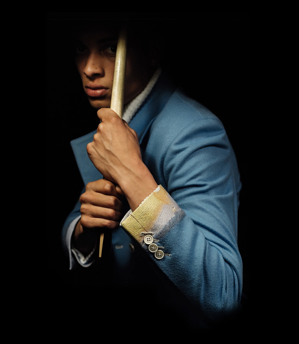 Model in a blue tailored jacket with a functioning sleeve vent, photographed in chiaroscuro lighting for PSEUDONYM Autumn Winter 2019.