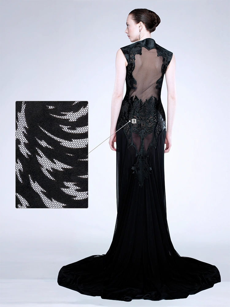 Back view of a black evening gown with sheer mesh and laser-cut appliqué detailing.