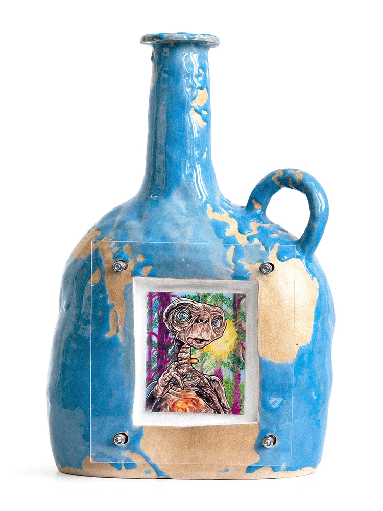 Blue glazed stoneware vessel with a colorful E.T. figure drawing secured beneath clear plexiglass with metal hardware.