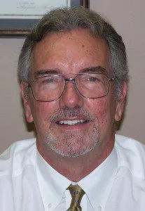 Smiling professional wearing glasses and white shirt with tie
