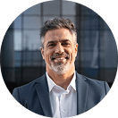 Lächelnder Mann im Anzug vor modernem Glasgebäude.