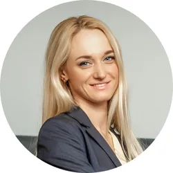 Smiling man with light skin and short hair wearing a black hoodie against a black background.