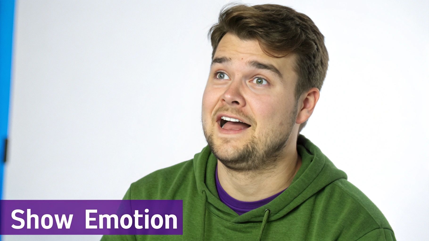 A young man in a green hoodie shows a surprised or excited expression, looking up.