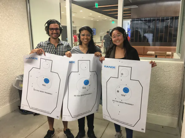 Wandr team holding targets at a shooting range