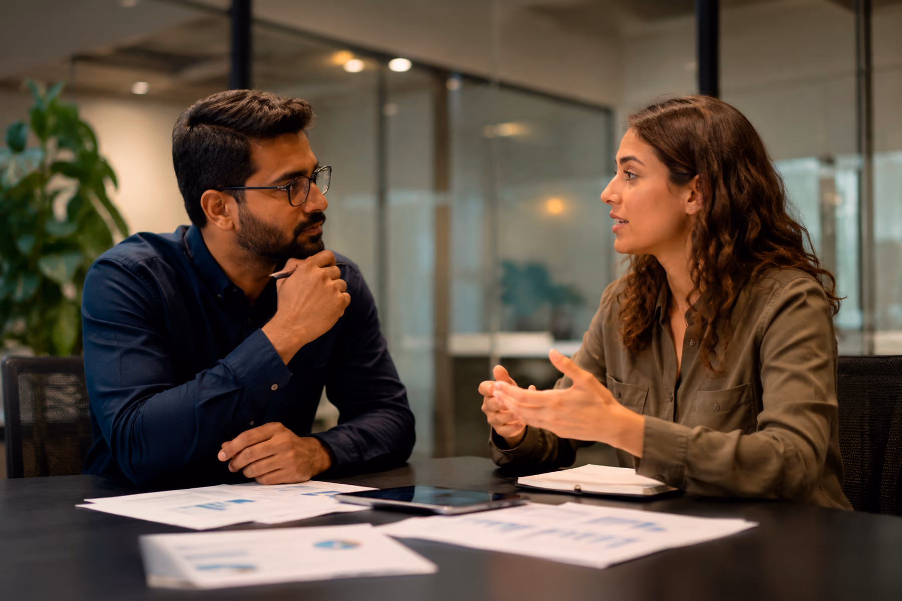 Two education decision-makers in a meeting reviewing EdTech procurement materials at a conference table