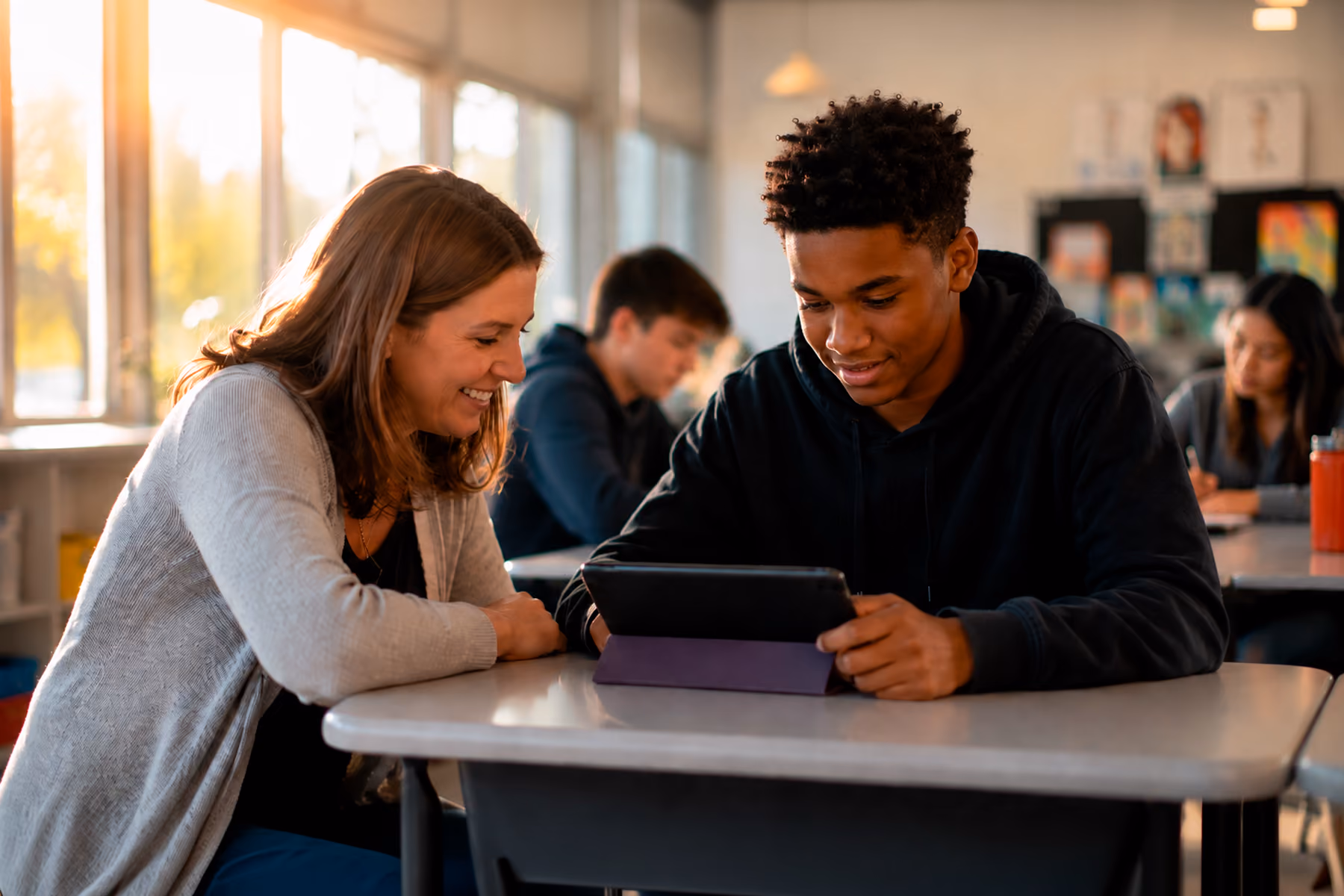 Teacher guiding a student using an AI-powered EdTech tablet in a modern classroom setting