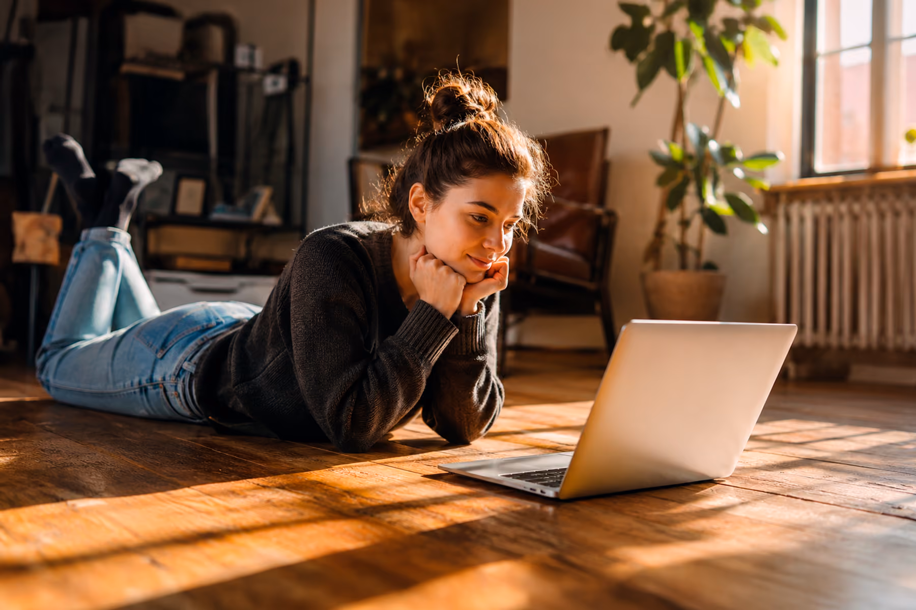 Creative professional lying on the floor engaged with a laptop, representing the focused and intuitive experience of browsing a well-designed website