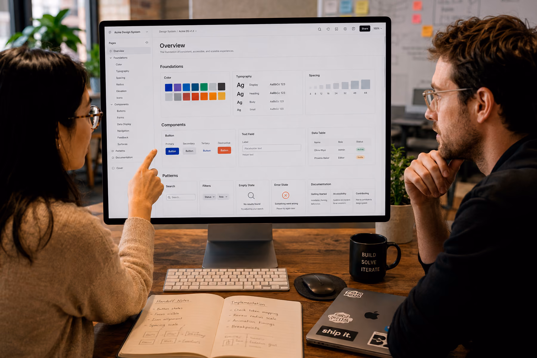 Designer and engineer reviewing comprehensive UX design system with component library, tokens, and documentation during handoff
