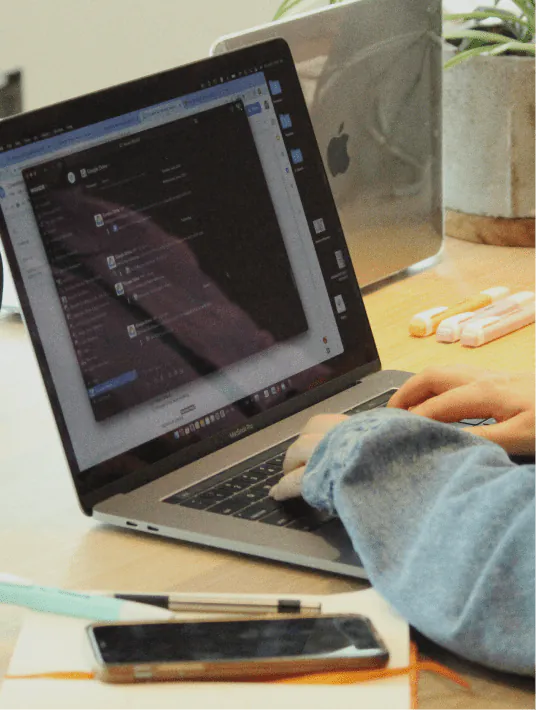 A product designer and UX designer collaborating at a whiteboard covered in wireframes, sticky notes, and user flow diagrams in a modern design studio.