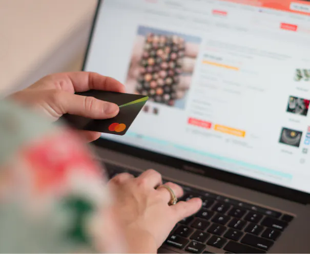 A fintech product designer reviewing a next-generation mobile banking interface on a smartphone and tablet, representing the shift from legacy financial systems to modern user-centered digital banking experiences.