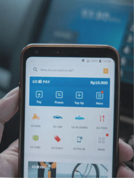 UX designer working on a FinTech mobile app interface displaying financial data, charts, and a clean dashboard layout on a desktop screen
