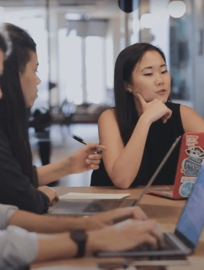 UX analyst reviewing a SaaS product audit report on a laptop with website analytics dashboards, user flow diagrams, and conversion rate data displayed on screen