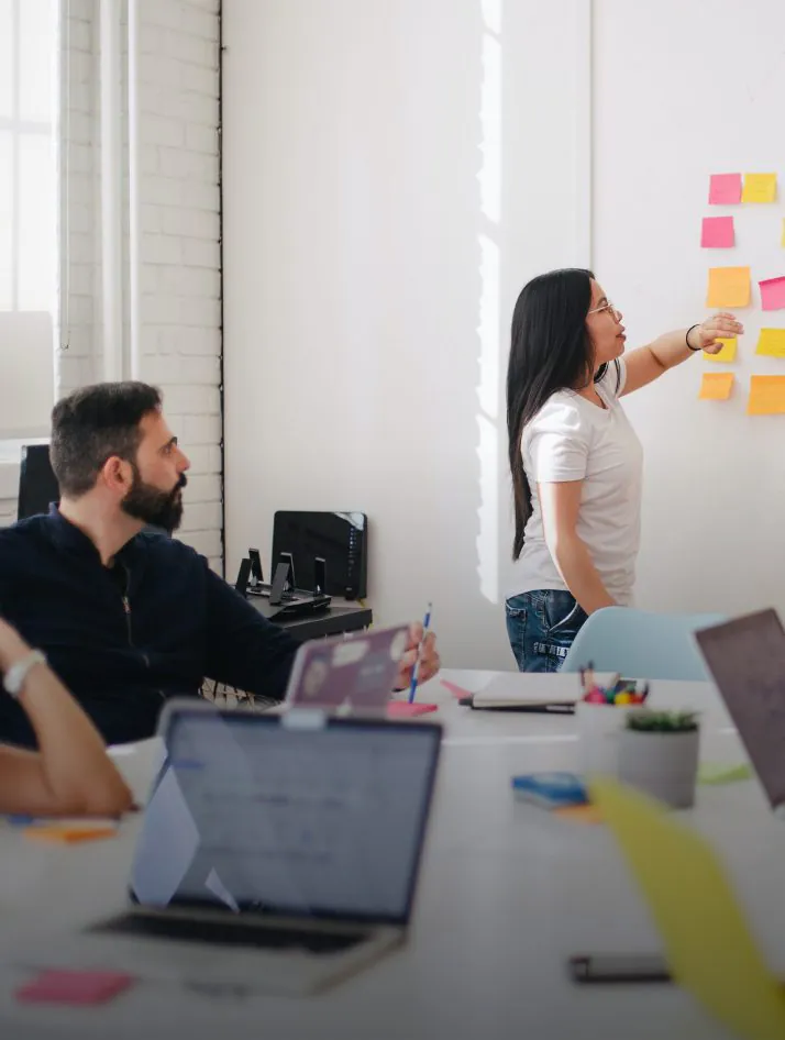 Team collaborating during a design thinking workshop using sticky notes, user journey maps, and brainstorming techniques to solve complex problems.