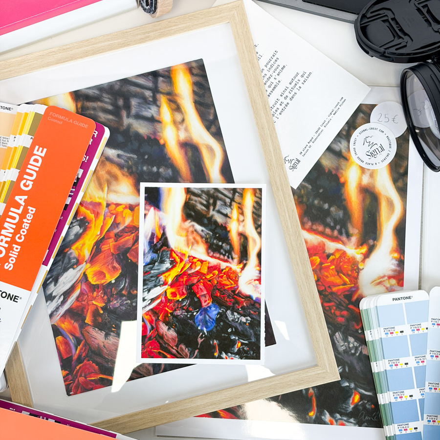 Plusieurs impressions d'une image de flammes et de braises avec des nuanciers Pantone dispersés autour.