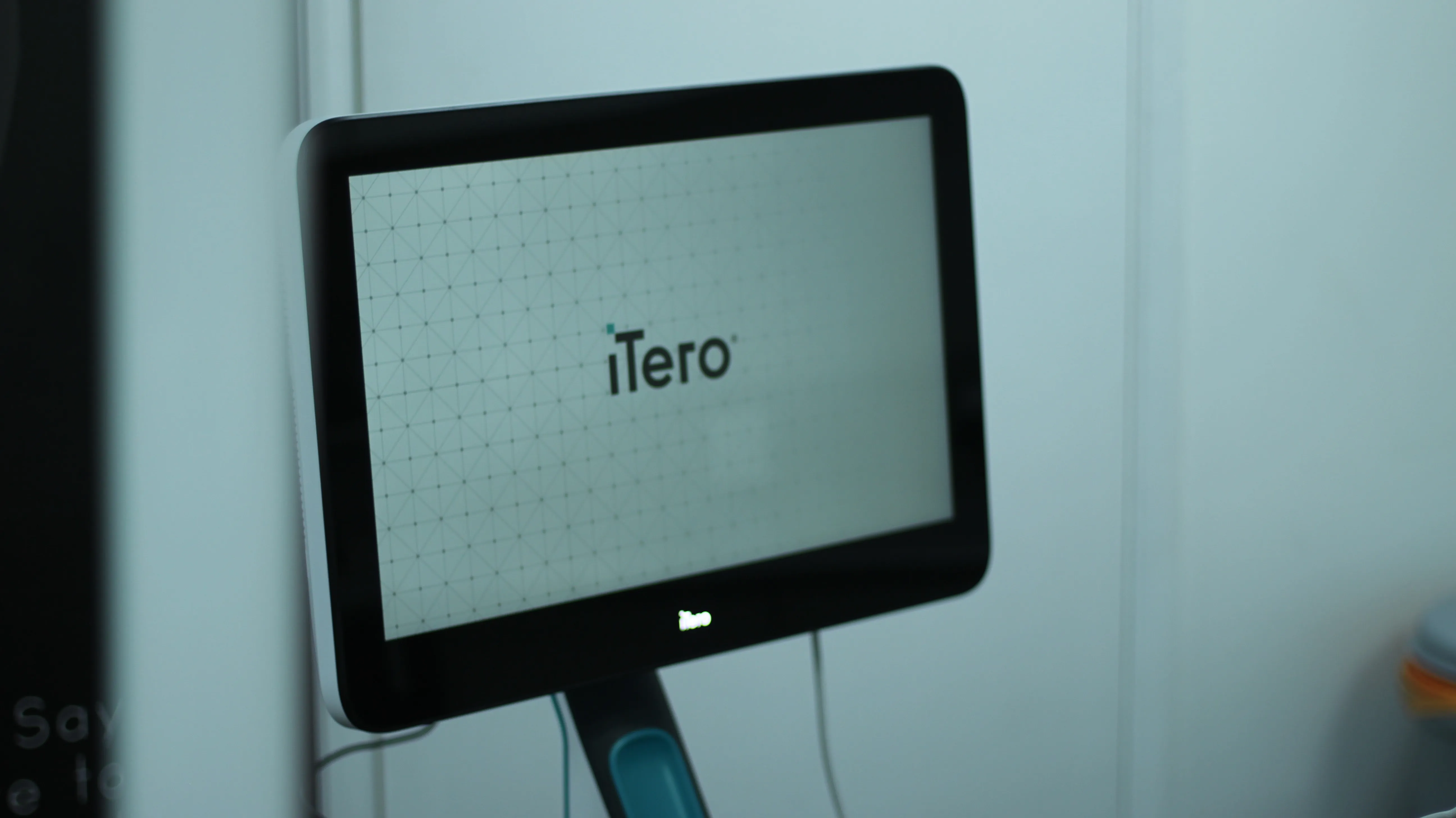 iTero digital scanner screen displaying its logo in a clinical setting.